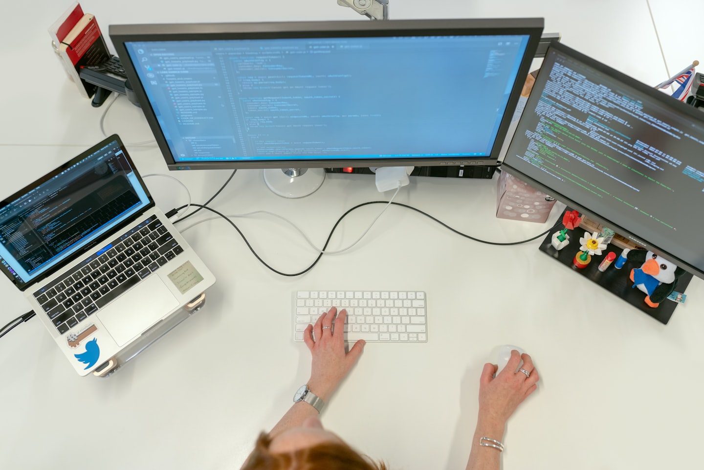 Developer coding on a multi-monitor workstation in an office.